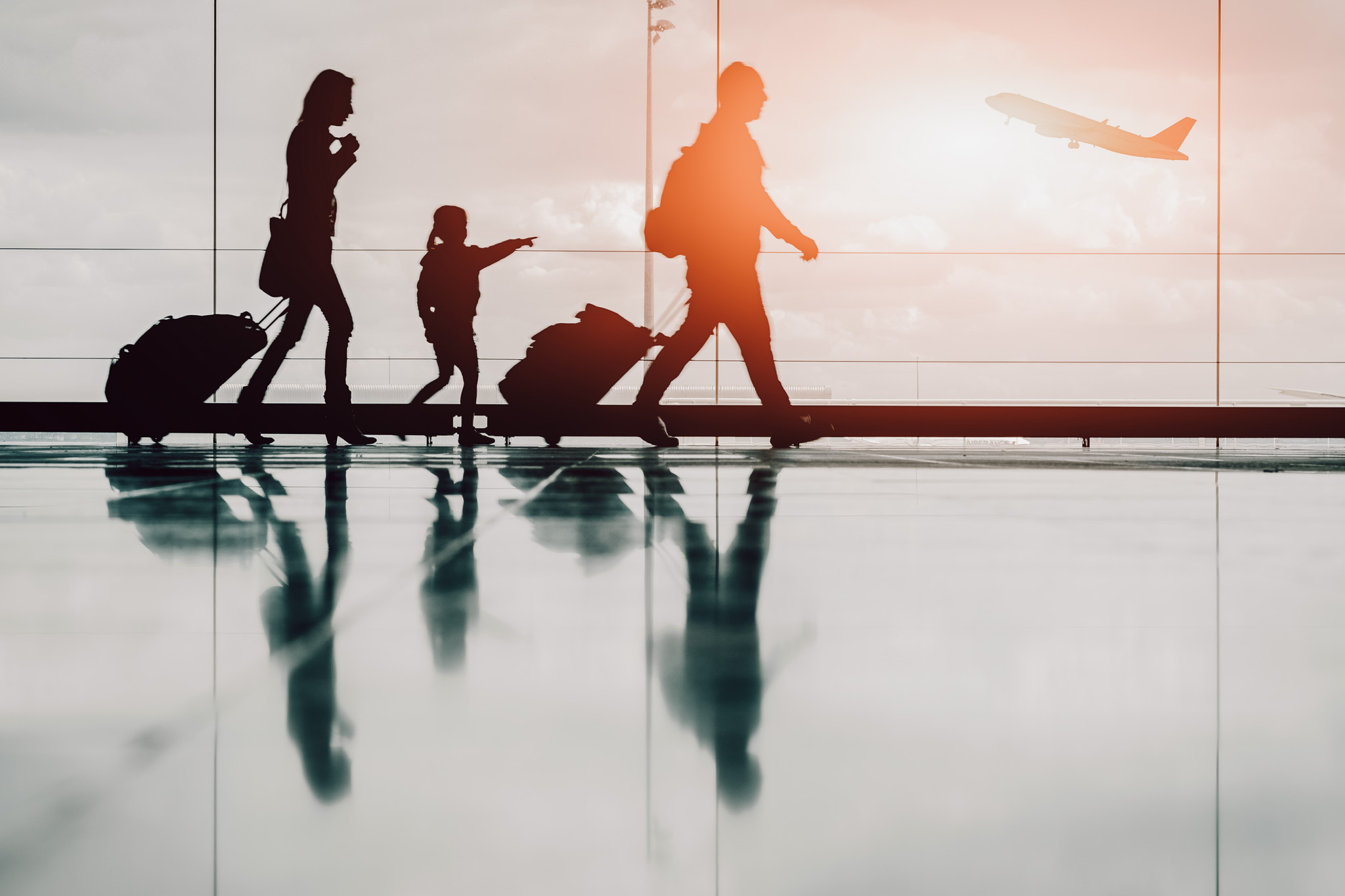 Silhouette of young family and airplane